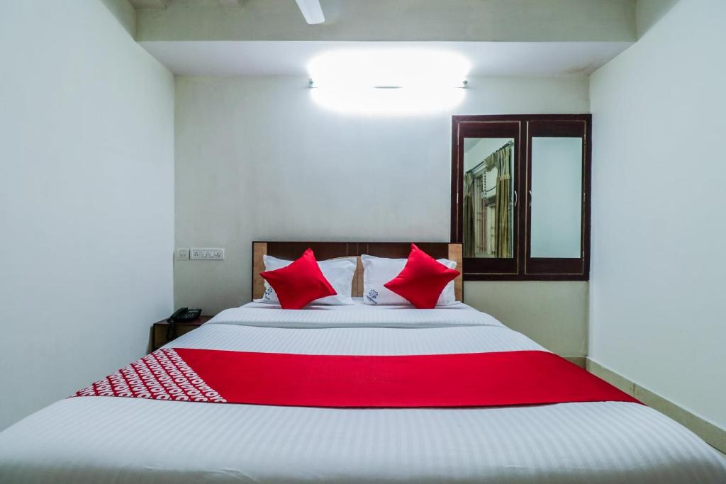 拉賈蒙德里的住宿－Parnasala Princely，一间卧室配有一张带红色枕头的大床