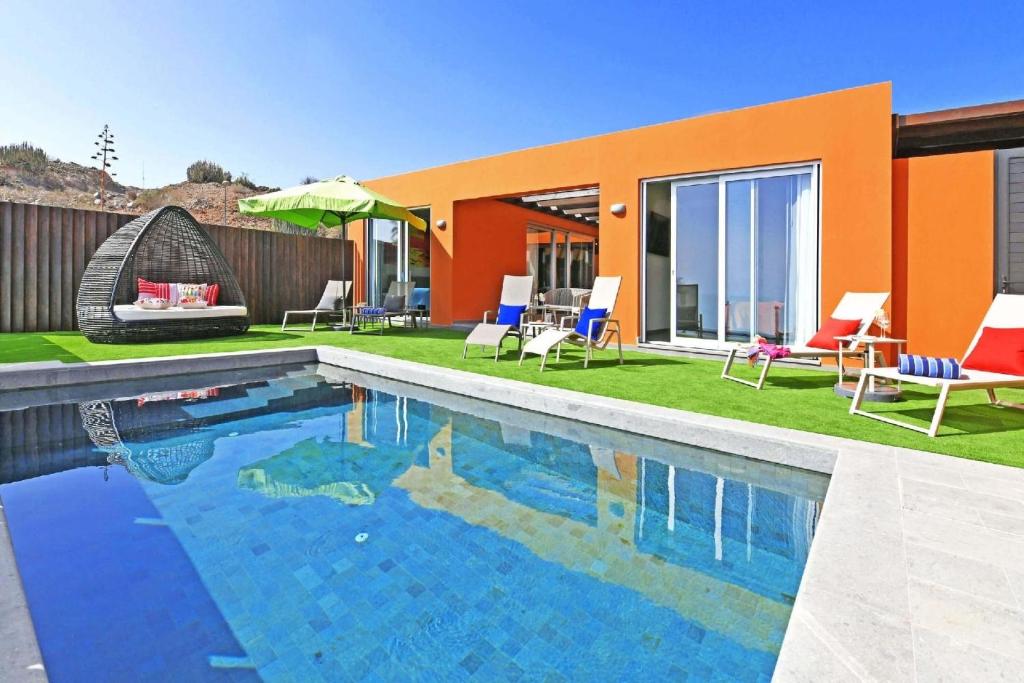 uma piscina com cadeiras e uma casa em Ferienhaus mit Privatpool für 6 Personen ca 122 qm in Las Crucitas, Gran Canaria Südküste Gran Canaria em Maspalomas