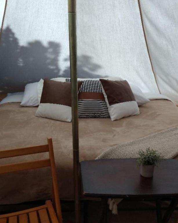 a bed with pillows and a table in a room at Olympic Glamping in Port Angeles