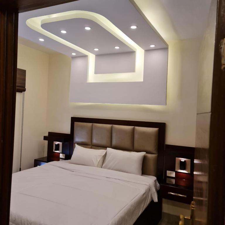 a bedroom with a large bed with a ceiling at 30th apartment in Amman
