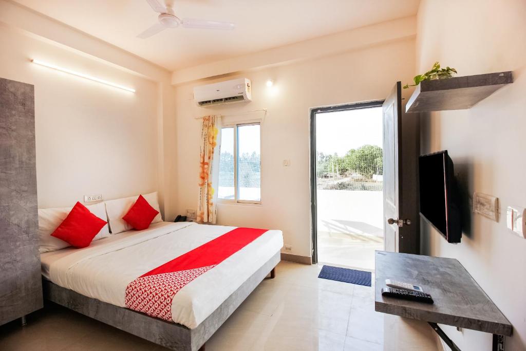 a bedroom with a bed and a tv and a window at D' Jade in Hyderabad
