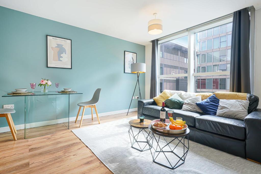 een woonkamer met een bank en een tafel bij City Centre Apartment with Free Parking, Super-Fast Wifi and Smart TV with Netflix by Yoko Property in Milton Keynes