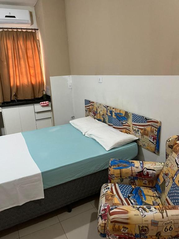 a room with a bed and two chairs in it at St. Benoit suites e hostel in Presidente Prudente
