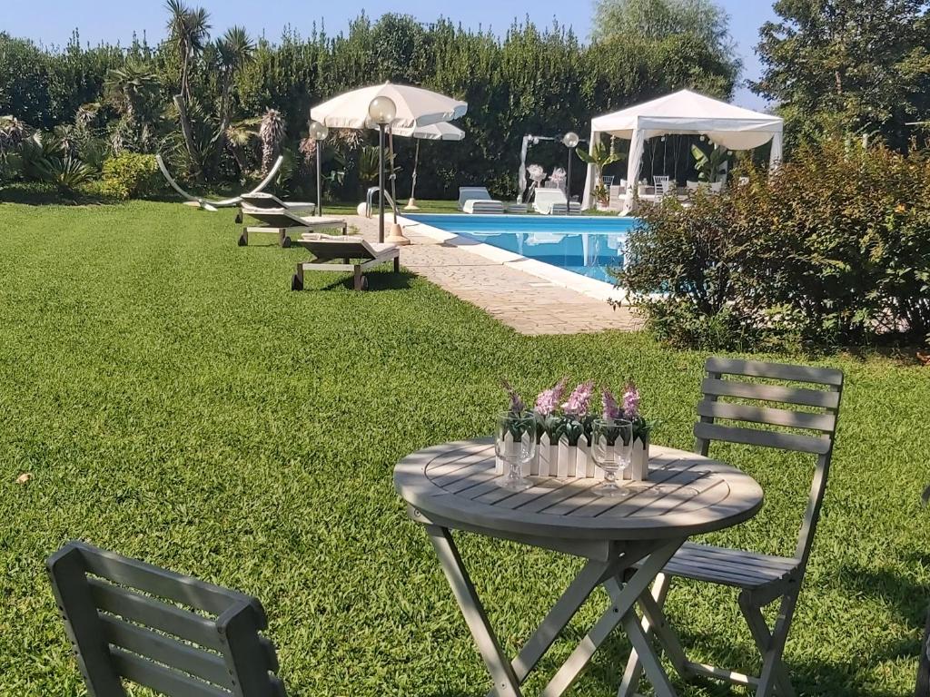 una mesa con jarrones de flores junto a una piscina en Villa Fioccomare, en Camaiore