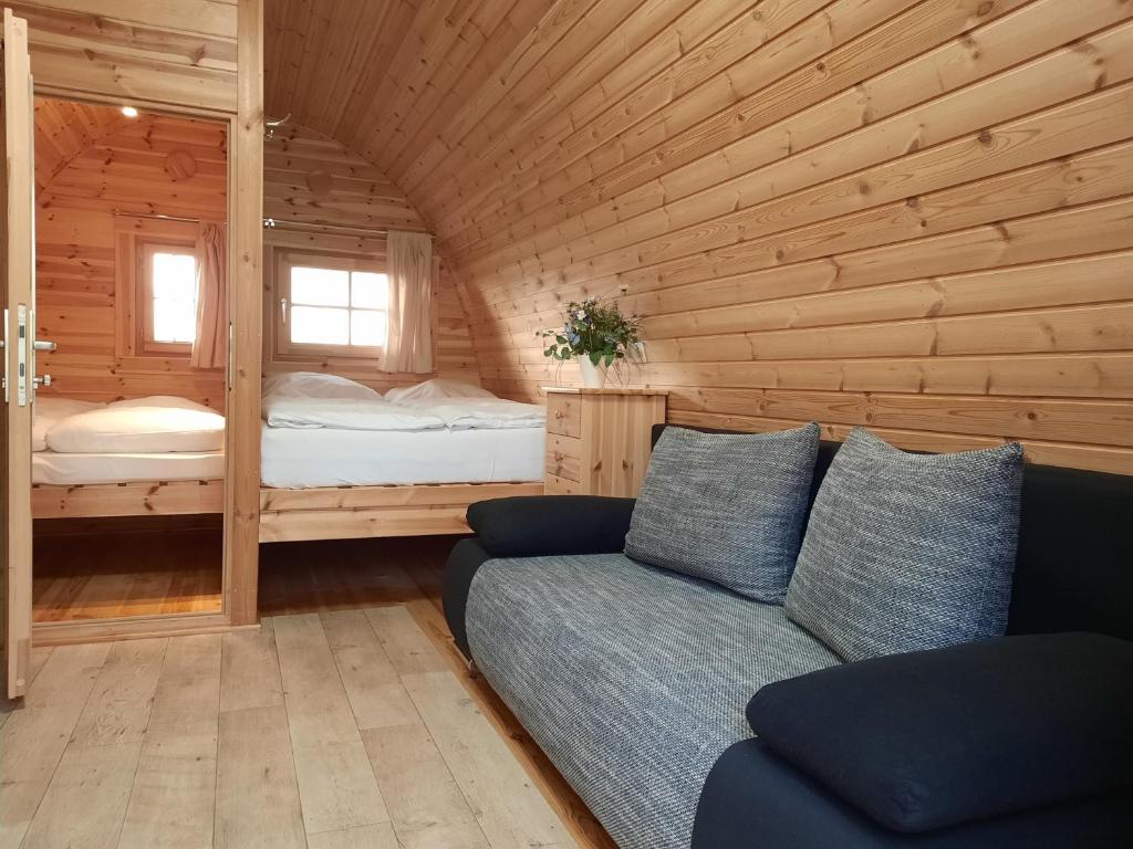 ein Wohnzimmer mit einem Sofa in einer Holzhütte in der Unterkunft 43 Camping Pod in Silberstedt