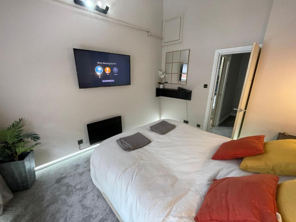 a bedroom with a large white bed with a flat screen tv at Luxury modern 1 bedroom house in Southampton