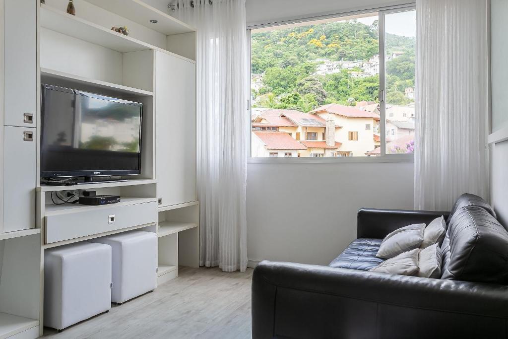 a living room with a couch and a tv and a window at 200m do Beiramar Shopping #CA44D in Florianópolis