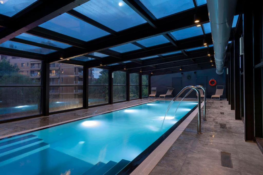 a swimming pool in a building with windows at Radisson Blu Hotel Milan in Milan