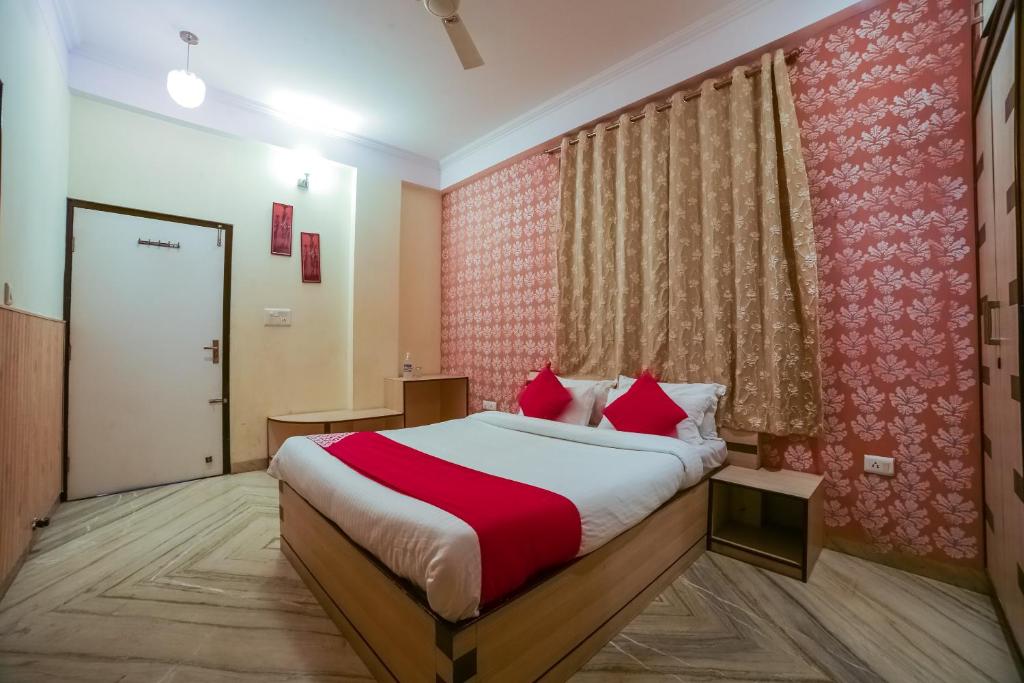 a bedroom with a bed with a red and white blanket at Capital O The Royal Palace in Jaipur