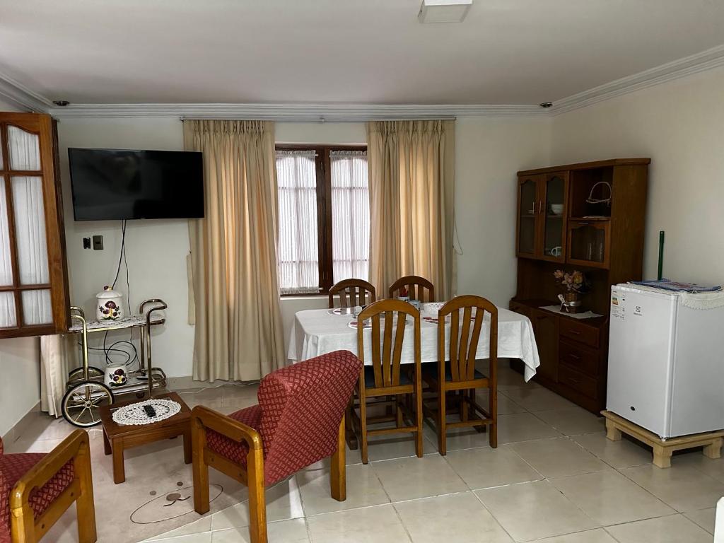 - un salon avec une table, des chaises et une télévision dans l'établissement Departamento con baño privado, à Sucre