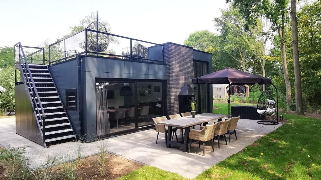 una casa negra con mesa y sillas en Strand & Veluwemeer - Cube Elite Premium Bad Hoophuizen en Hulshorst