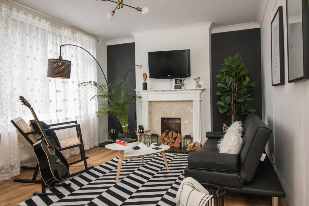 a living room with a couch and a fireplace at Oasis in English Village in Crowthorne