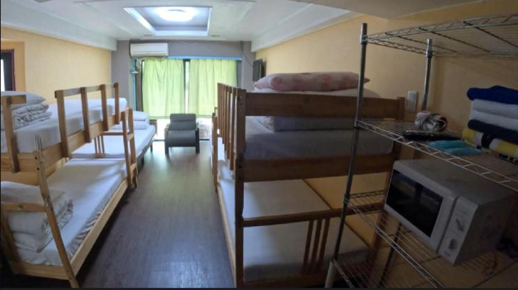 a room with three bunk beds and a television at Sophiearth Apartment in Tokyo