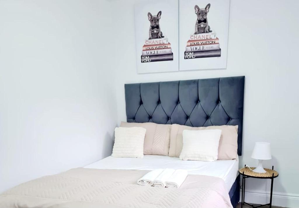 a bedroom with a bed with a blue headboard at Modern Luxurious New Build Entire 2 Bedroom Apartment in Basildon