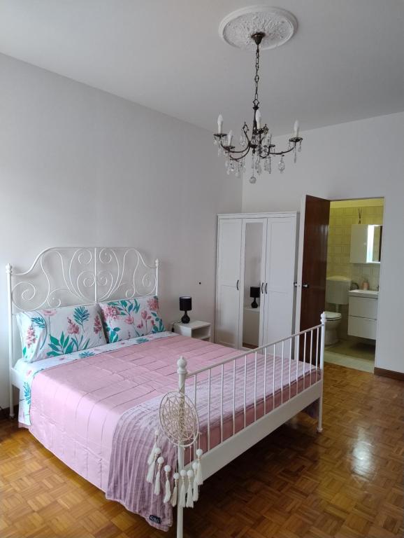 1 dormitorio con cama y lámpara de araña en La Casa di Giulia, en Ancona