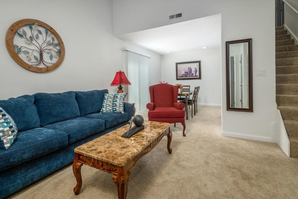 uma sala de estar com um sofá azul e uma cadeira vermelha em Lofty Haven, your home away from home! em Huntsville