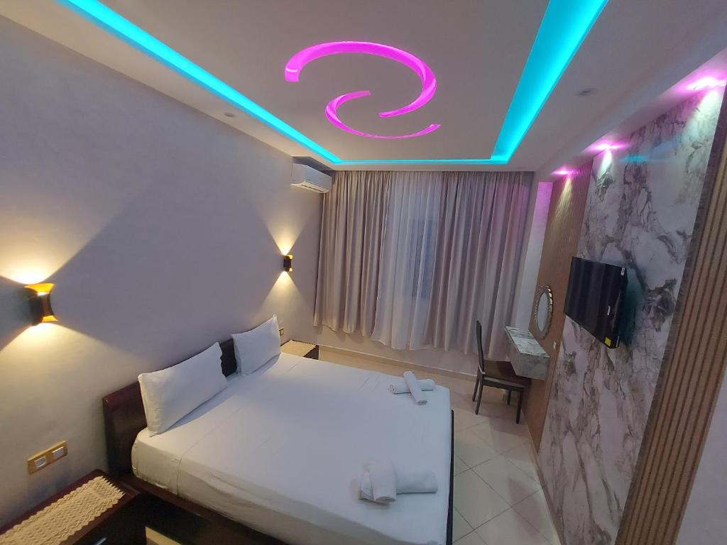 een slaapkamer met een bed met een neonbord aan het plafond bij borj rayhane 1 in Tanger