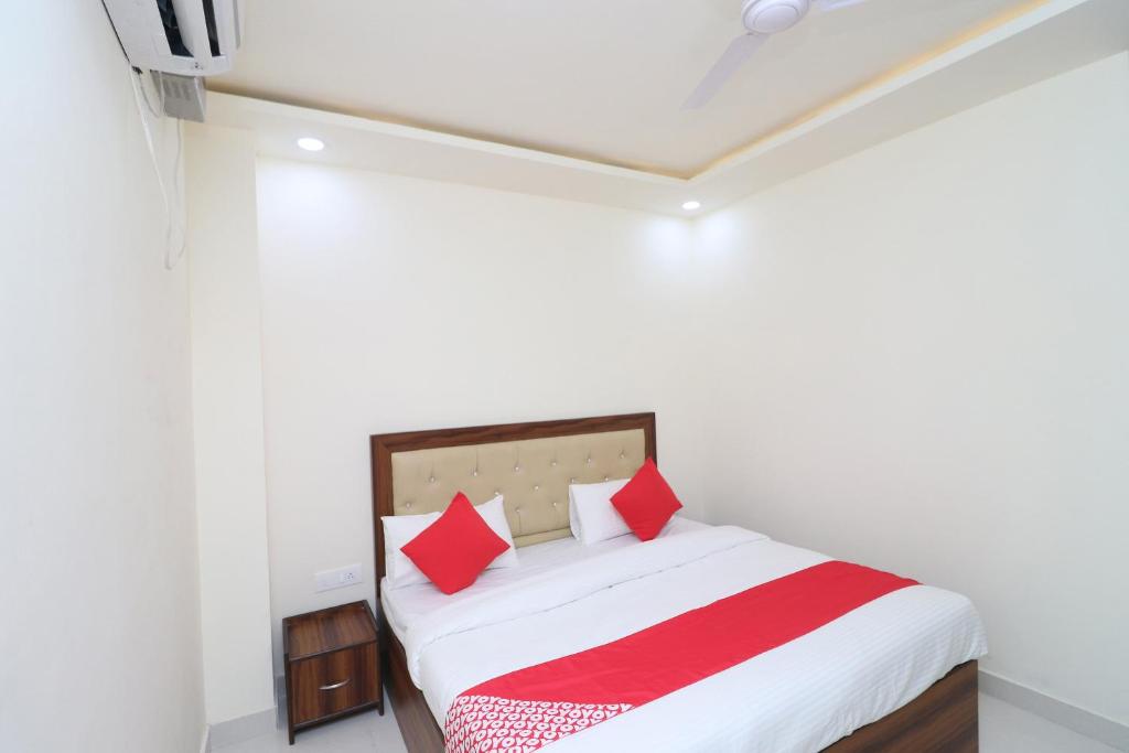 a bedroom with a bed with red pillows at OYO Hotel Dezzire in Ballabgarh