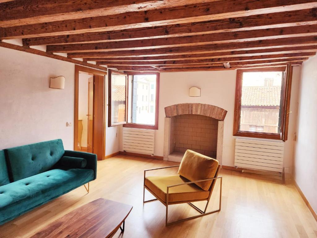Lo Squero apt في البندقية: غرفة معيشة مع أريكة ومدفأة