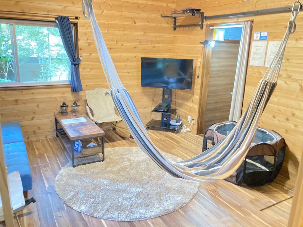 那须町ペットと泊まれるロフト付建物｜CHILL SWING チビ的客厅设有吊床和电视。