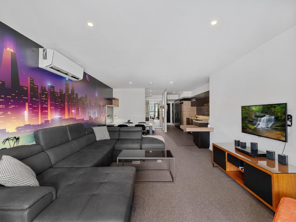 a living room with a couch and a tv at Discover urban bliss in our 1-bedroom King bed apartment! City views and cultural gems in Brisbane