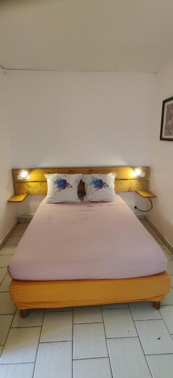 Posto letto in camera con pavimento bianco. di Bungalow Touloulou (Mi) à 10mn à pieds des plages a Le Gosier