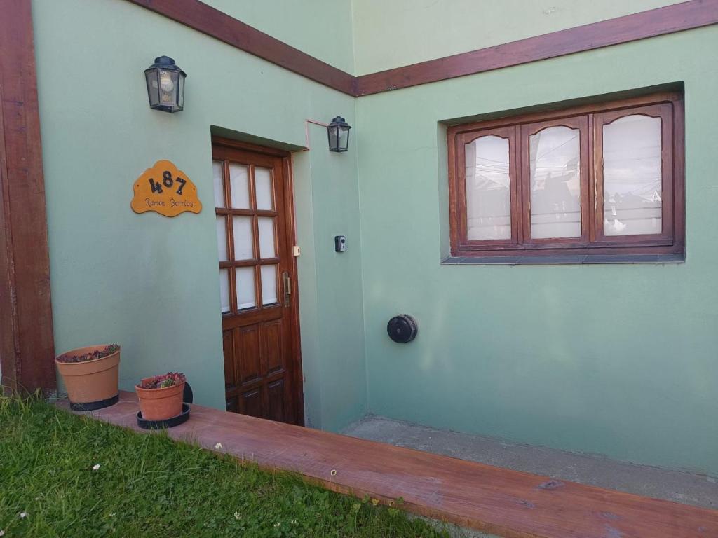 a house with a door and a window and a porch at BZ Apartment in Ushuaia