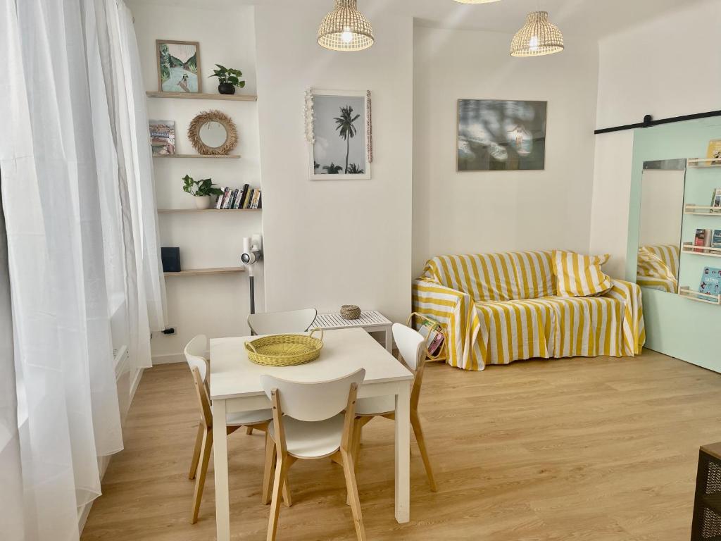 - un petit salon avec une table et des chaises blanches dans l'établissement Confort & Calme - Proche de la mer, métro, centre ville et stade, à Marseille