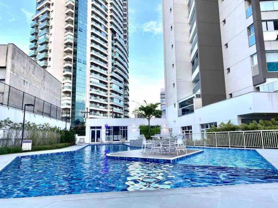 a swimming pool in the middle of two tall buildings at 1811 - Rentaqui Summint Premium Pinheiros in Sao Paulo