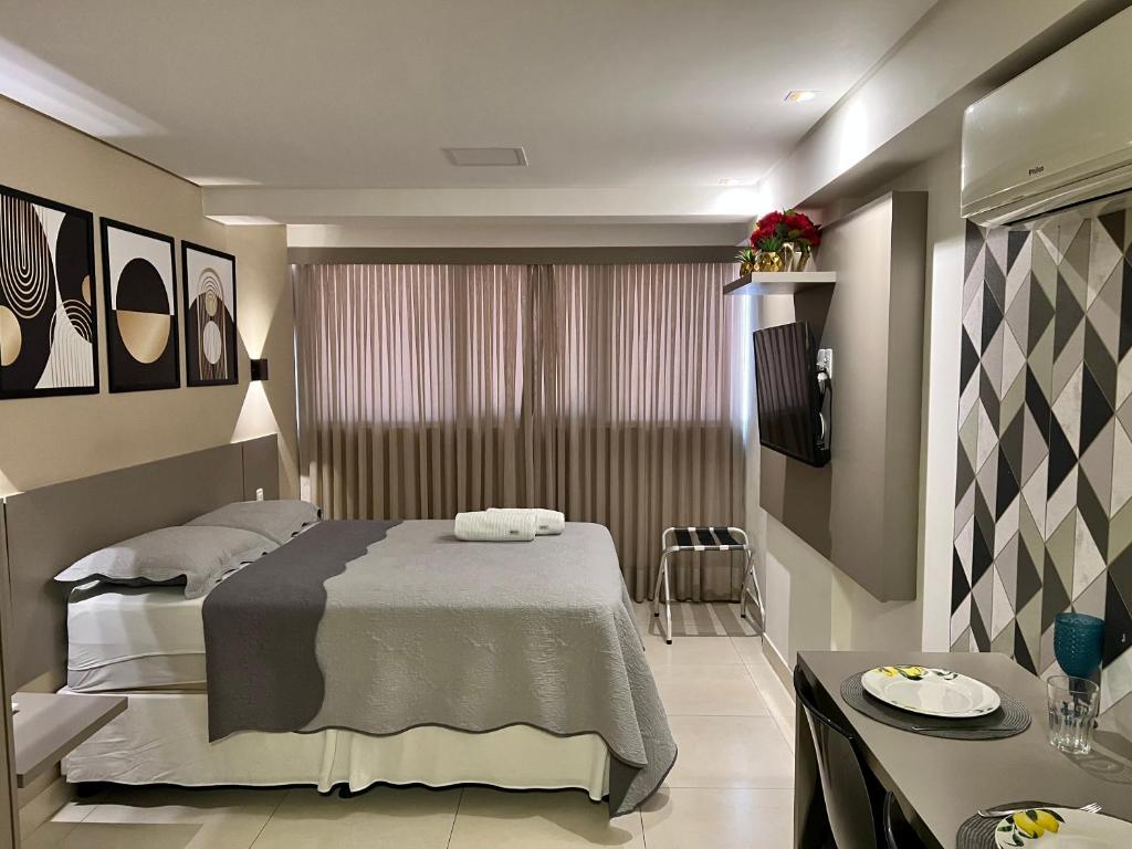 a bedroom with a bed and a table in it at GOLD FLAT MANAÍRA 1705 in João Pessoa