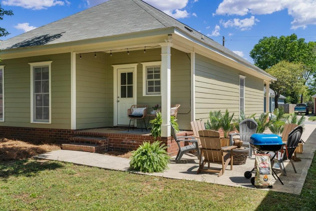 een klein groen huisje met stoelen en een terras bij Single Story Fire Pit Updated Close to Downtown in Columbus