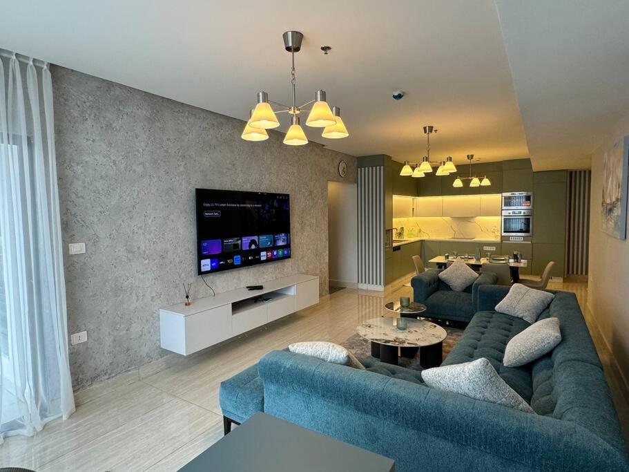 un soggiorno con divano blu e TV di Amazing brand-new apartment in Abdoun! ad Amman