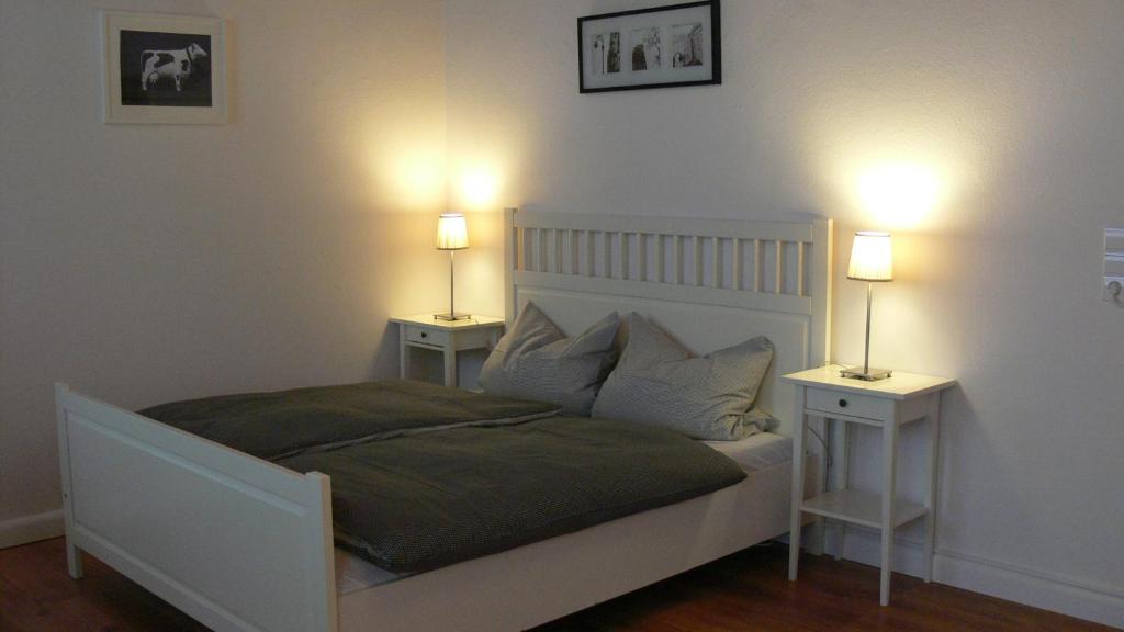 um quarto com uma cama branca com duas mesas de cabeceira em Business Flat Bahnhofstraße em Wiesbaden