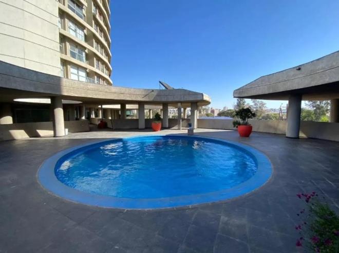 una gran piscina azul frente a un edificio en Sonoma Ribera- Gral Paz CBA en Córdoba