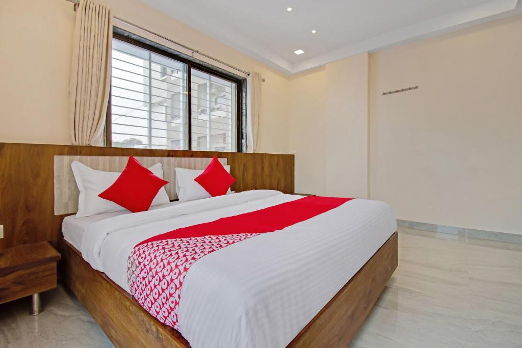 una camera da letto con un grande letto con cuscini rossi di Super Capital O Hotel C Tara a Shirdi