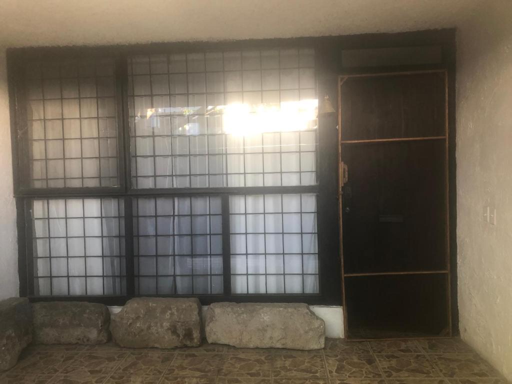 ein leeres Zimmer mit einer Tür und einem Fenster in der Unterkunft San Gabriel’s House at Chapalita(Colonia) in Guadalajara