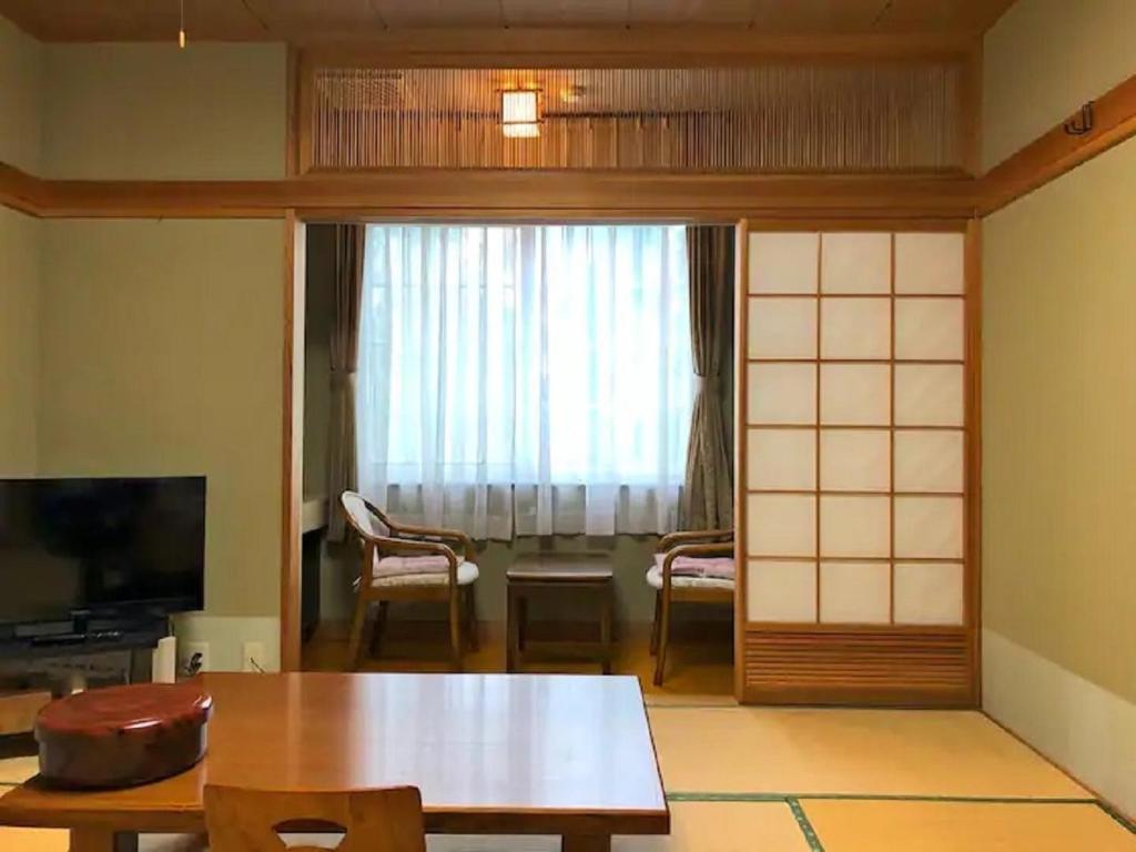 a living room with a table and a window at Koguriyama Sanso - Vacation STAY 43377v in Minami Uonuma