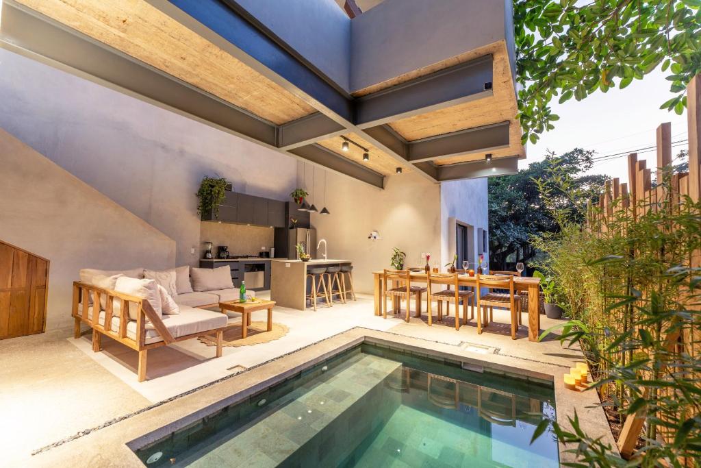 an outdoor patio with a swimming pool and a kitchen at Alma Tropical - 4 Unit Luxury Villa Experience Santa Teresa in Santa Teresa Beach