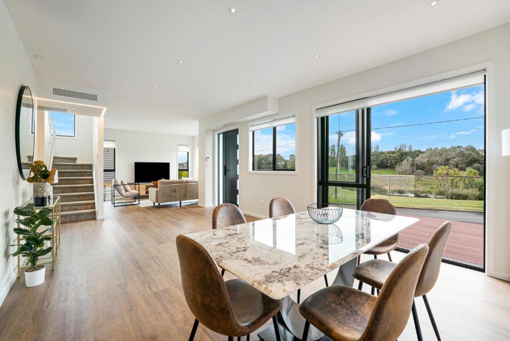 a dining room and living room with a table and chairs at Devonport Beach Front Home in Auckland