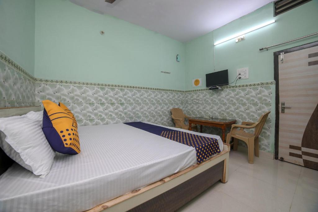 a bedroom with a bed and a table with a television at SPOT ON Hotel Ramgiri in Rāmtek