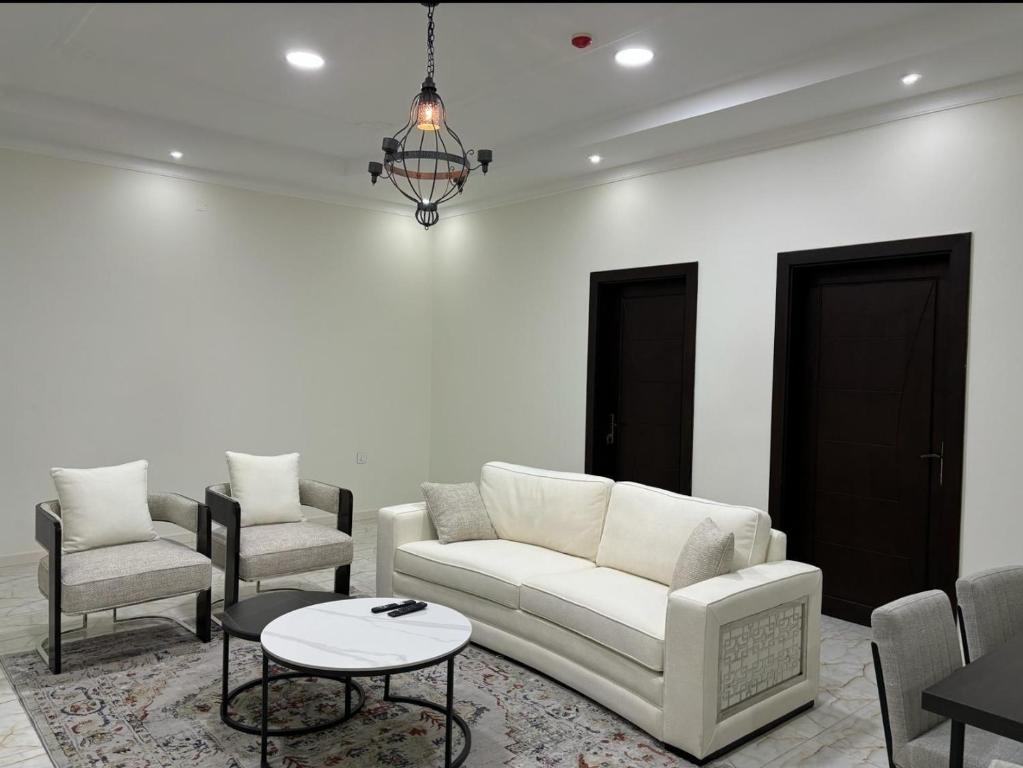 MFAPARTMENT في Al Budayyiâ€˜: غرفة معيشة مع أريكة وكرسيين وطاولة