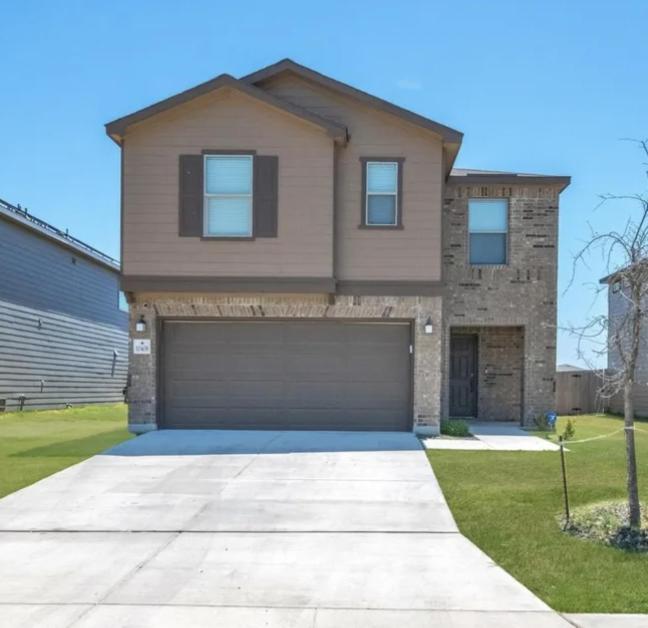 een groot huis met een garage in een tuin bij Spacious Room for Rent: Conveniently Located near Highway 1604! in San Antonio