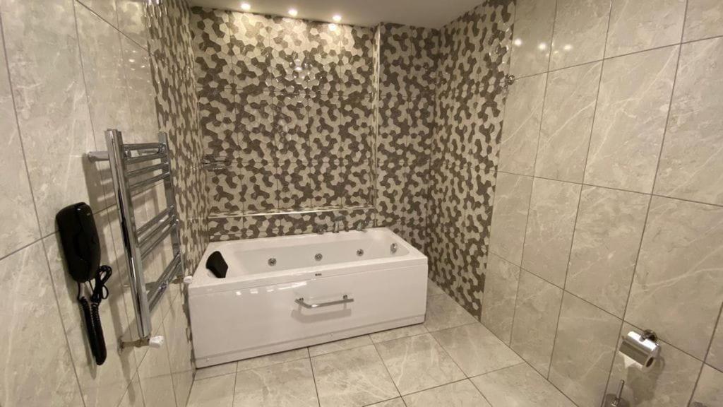 a bathroom with a tub in the corner of a shower at YASON BLUE SUIT OTEL in Perşembe