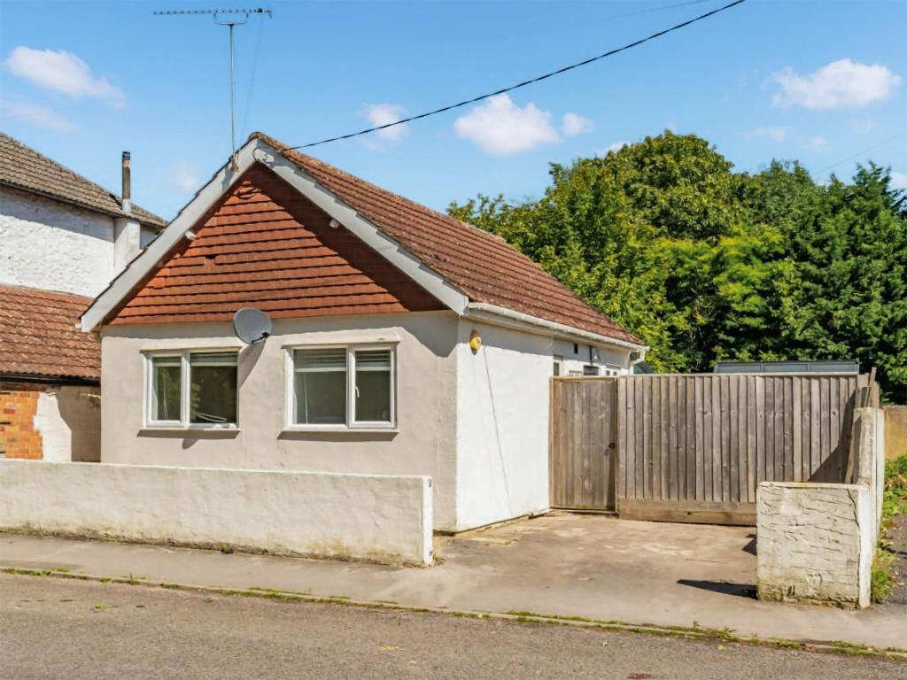 a small white house with a wooden fence at Hh-the Old Chippy in Codford