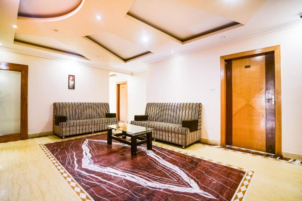 ein Wohnzimmer mit 2 Sofas und einem Tisch in der Unterkunft Super Capital O Hotel All Seasons in Jamshedpur