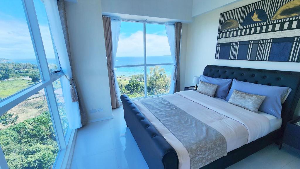 a bedroom with a large bed with a large window at La Mirada Residences in Mactan