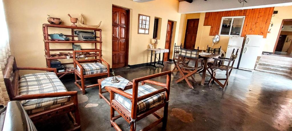a living room with wooden chairs and a table at Hospedaje Familia Sandoval in Tilcara
