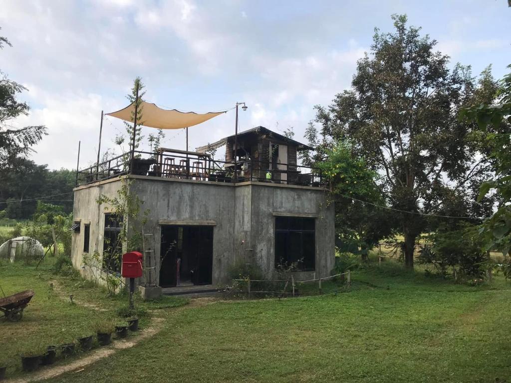 an old building with a tent on top of it at สวนบ้านนอก SuanBaanNoak in Ban Phaet