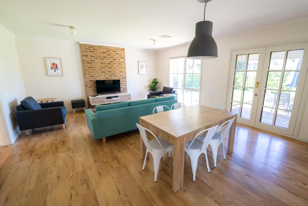 a living room with a wooden table and chairs at The Royal Cottage in Mildura