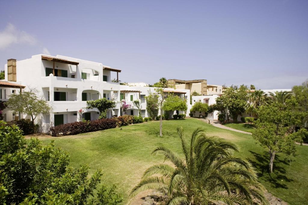 a large white house with a green yard at ROBINSON ESQUINZO PLAYA - All Inclusive in Morro del Jable